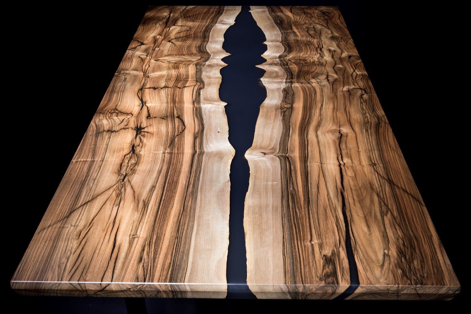 The English Creek table from above: bookmatched English walnut with pale sapwood edges and a black epoxy river down the center