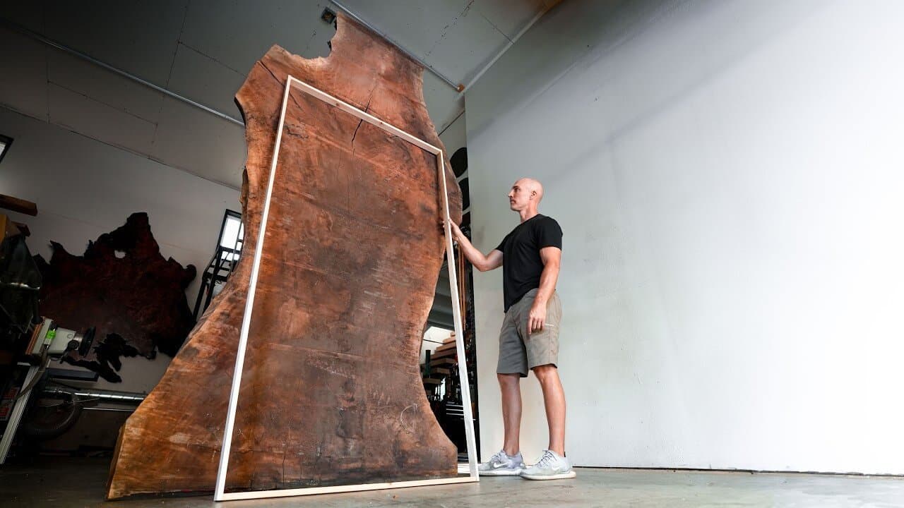 Cam standing beside an eleven-foot slab of walnut in the shop