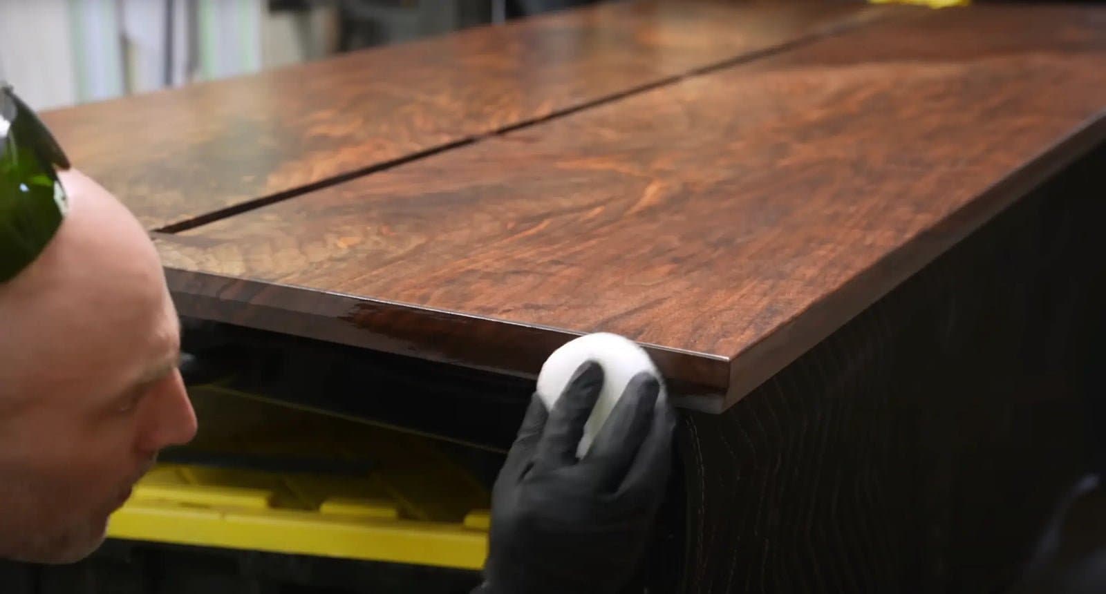 Cam working a finish into a walnut tabletop in the shop