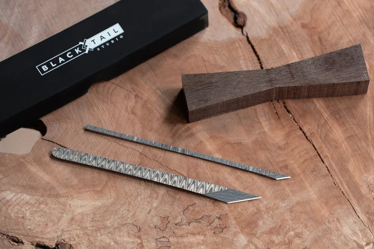 The Precision Edge and Toothpick marking knives on a walnut offcut beside their box
